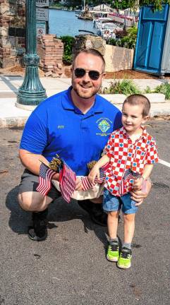 Peter and Levi Smith hand out flags for the Knights of Columbus at the Fourth of July Parade in Sparta.