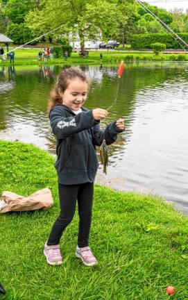 Ava Munoz looks at her first fish. Many of the Trout Derby participants were fishing for the first time.