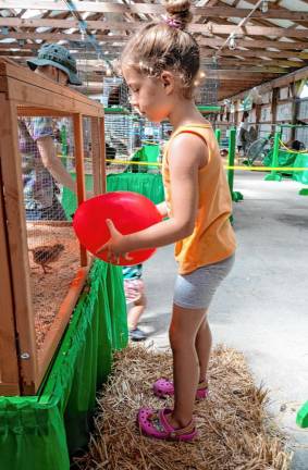 <b>Brielle Morris looks at a chick. (Photo by Nancy Madacsi)</b>