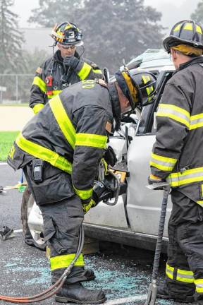 Firefighters demonstrate how to extricate a passenger from a vehicle.