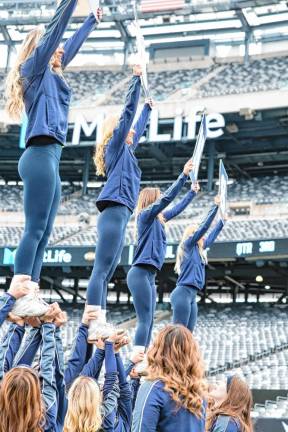 The Pope John cheerleaders do a stunt along the Lions sideline at MetLife Stadium.