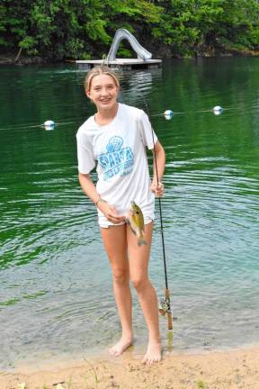 Aubrey Tropona holds a fish she caught.