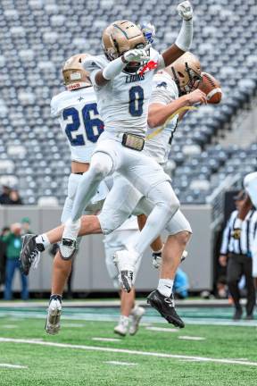 Joseph Rozynski, right; Prince Joshua, center; and Luke Gialanella celebrate a Lions first-half score against DePaul.