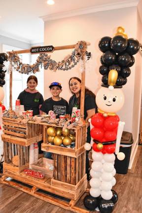 Emma Aguado and Vincent Volpe, both of Sparta, and Alisha Santos of Andover Township sell hot cocoa.