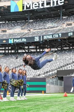 Pope John senior Marissa Marston does a stunt along the Lions sideline during a second-half timeout.