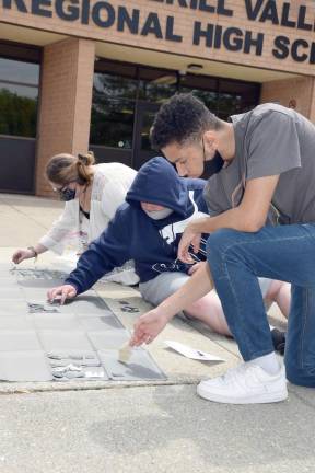 From front to back: Jaden VanDunk, Joseph Beviano, and Caitlin Collins create a classwide cynotype mural (Photo by Laura J. Marchese)