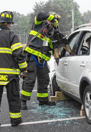 Firefighters demonstrate how to extricate a passenger from a vehicle.