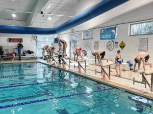 OLY1 Kate Douglass, a 2024 Olympic champion in the 200-meter breaststroke, races swimmers in the Sussex County YMCA pool. (Photos provided)