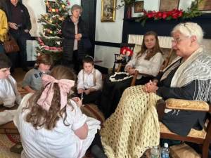 <b>Gail Shawger with her ‘grandchildren’ shows what Christmas was like in 1916 during the annual Christmas in July open house last year at the Elias Van Bunschooten Museum in Wantage. (File photo by Daniele Sciuto)</b>