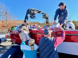 <b>Volunteers unload toys filling a Nautique boat Dec. 12, 2023, at Project Self-Sufficiency in Newton. (File photo courtesy of Project Self-Sufficiency)</b>