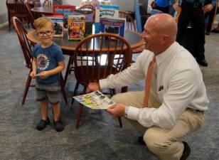 Detective Sgt. Brian Hassloch makes friends with Joey Drongoski of Sparta during the Coffee with a Cop event last fall. (File photo by Nancy Madacsi)