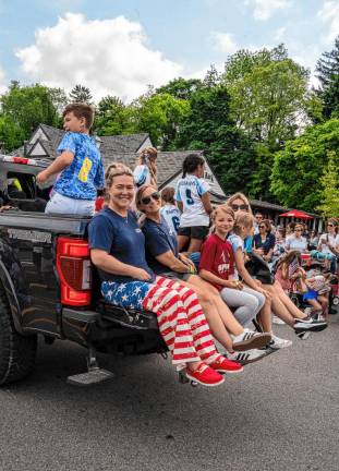 Softball team members ride in the parade.