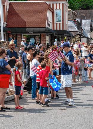 Councilman Daniel Chiariello hands out flags to the parade watchers.