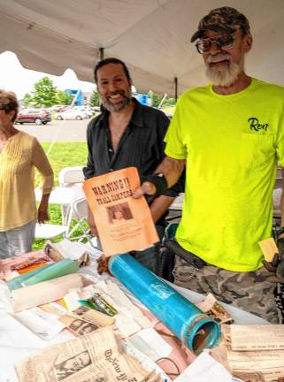 James Kimble and Ron Constable with a flier from the 1969 Woodstock Music and Art Fair found in the time capsule.