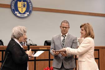 Marjory Murphy is sworn into office as a Township Council member. Her nephew Mark Lotz holds the Bible and Township Clerk Roxanne Landy administers the oath.