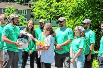 FR1 O’Leary Roofing employees present gifts as well as a free roof to Cindy Wrisley of Sparta. (Photo provided)