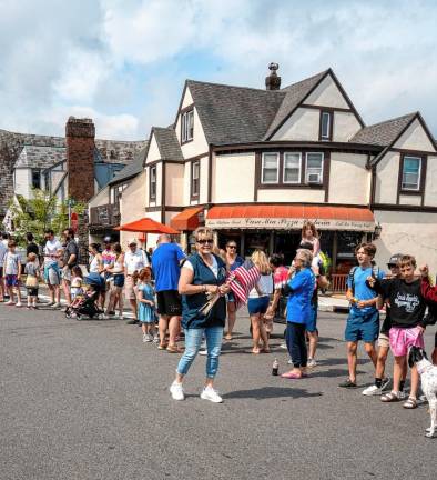 Councilwoman Christine Quinn hands flags to the parade watchers.