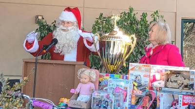 Santa speaks at the launch of Project Self-Sufficiency’s annual Season of Hope toy drive Oct. 25. At right is Deborah Berry-Toon, executive director of the nonprofit organization. (Photos by Kathy Shwiff)