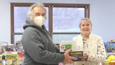 Toy drive organizer Bob Winter helps volunteer Dawn Schofer organize the donations (Photo by Janet Redyke)