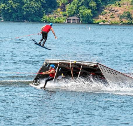 Damon Jenkins does a helicopter off the ski jump as Chris Andres does a cut under.