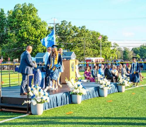 Graduates cross the stage to receive their diplomas.