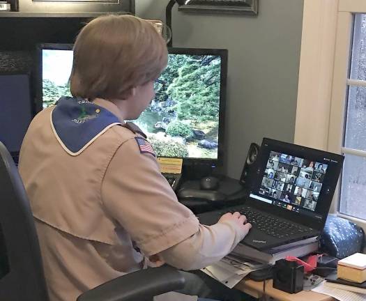 Life Scout Jonathan B. sits at his laptop participating in the virtual Troop meeting