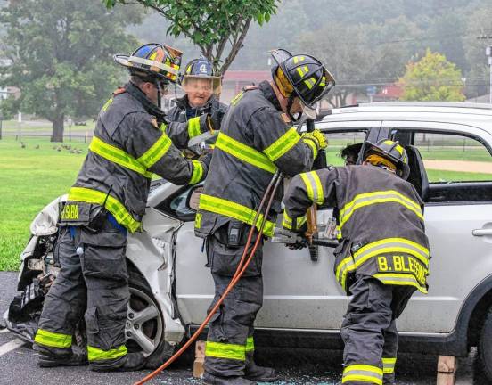 Firefighters demonstrate how to extricate a passenger from a vehicle after a crash.