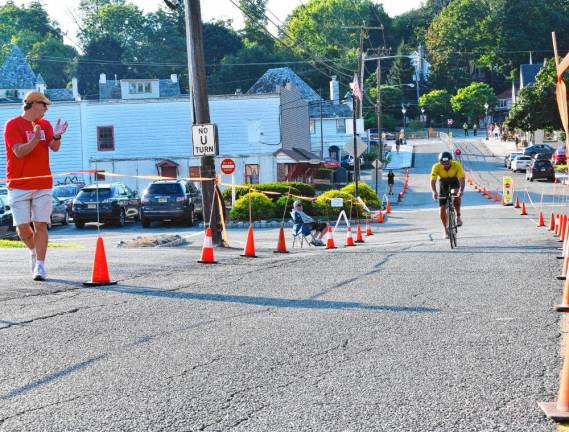 A man cheers on a cyclist in the second leg of the triathlon.