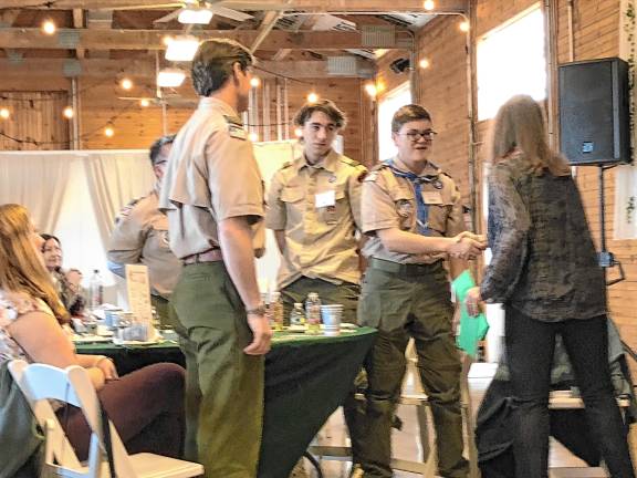 <b>Sabine Watson, right, president of the German Christmas Market of New Jersey, presents a check to members of Scouting America Troop 150 of Sparta. (Photos by Kathy Shwiff)</b>