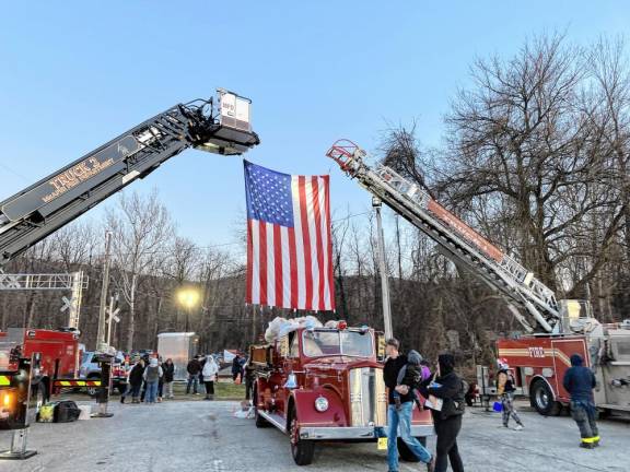 <b>The Vernon Fire Department hangs a large American flag at the train crossing. (Photo by John Benson)</b>