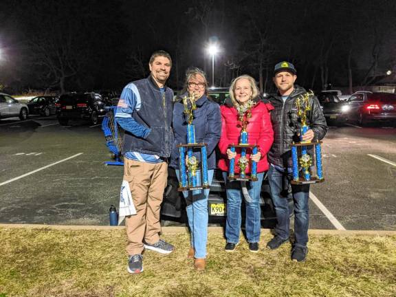 The archery team’s coaches with trophies won at the state tournament in February.