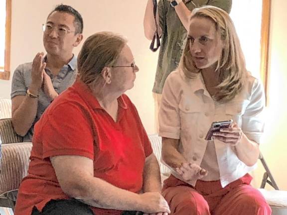 Sue Altman, right, talks to a resident after the town hall meeting.