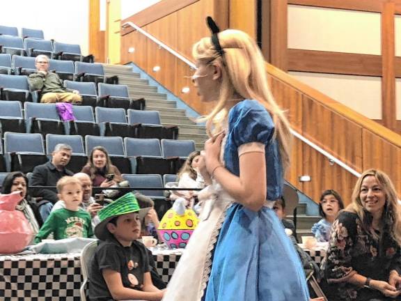 <b>The Sparta Middle School student playing Alice sings during the Mad Hatter’s Tea Party. </b>