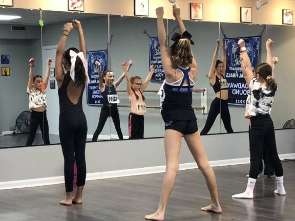 Girls ages 8-12 perform in front of a mirror during the auditions.