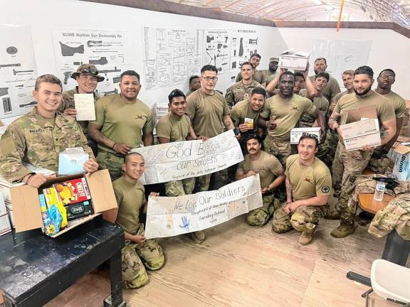 Sgt. Ryan Wood and other New Jersey National Guard soldiers receive 24 boxes of nonperishable snack foods gathered by the congregation of Shepherd of the Hills Lutheran Church in Sparta. The Sparta Kiwanis Club and church members donated cash to pay the $552 mailing charge. (Photo provided)