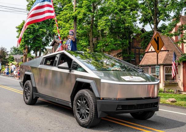 A Tesla pickup, priced from $189,000, is driven in the parade.