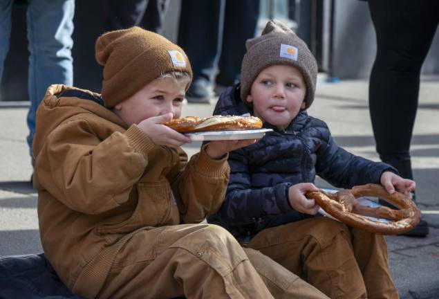 Warren Cramer, 5, of Green Township takes a bite out of his pretzel as his cousin Silas Van Haste, 4, of Green Township licks his lips after taking a bite of his pretzel.