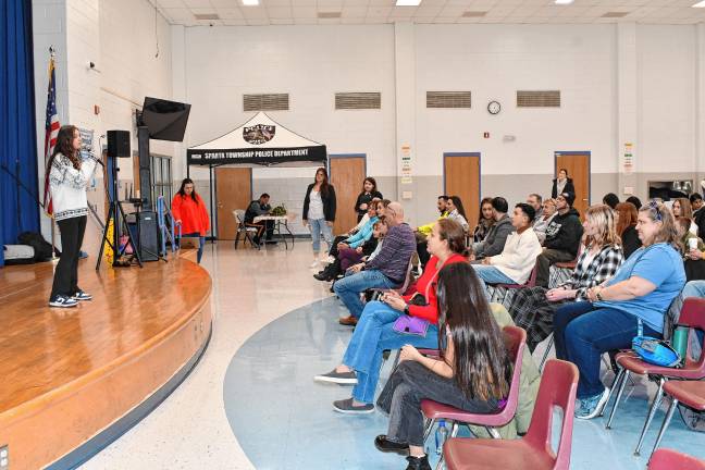 The audience watches a music student perform.