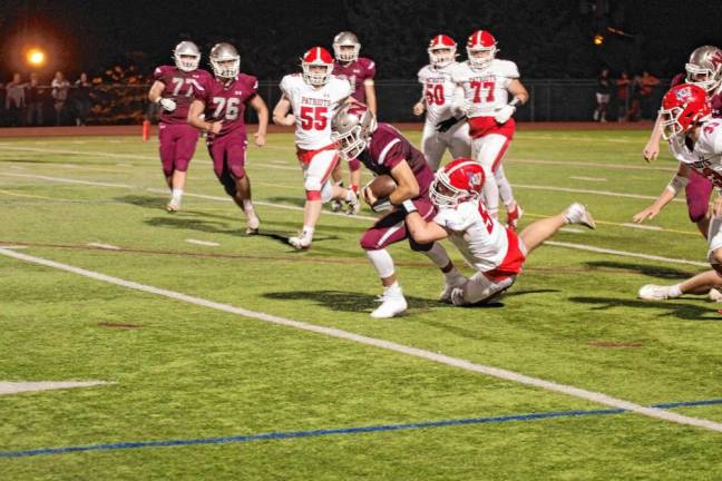 <b>Newton quarterback Matt Ellsworth is tackled by Lenape Valley defender Jack Phelps in the first half. Ellsworth threw one touchdown pass in the game, which the Patriots won, 19-7, on Friday, Sept. 13. (Photos by George Leroy Hunter)</b>