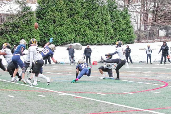 Pope John defenders Alex Schreiber (18) and Nick Vannatta (21) come close to blocking the ball during an extra-point kick attempt by Saint John Vianney in the first half.