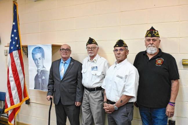 From left are Carmen Turrisi Jr.; Harry Kaplan, past commander of American Legion Post 86; Richard Escobar, commander of Post 86; and Frank Smith, commander of Veterans of Foreign Wars Post 5360. They are standing with a photo of Cornelius ‘Neal’ Faber, who served in World War II.