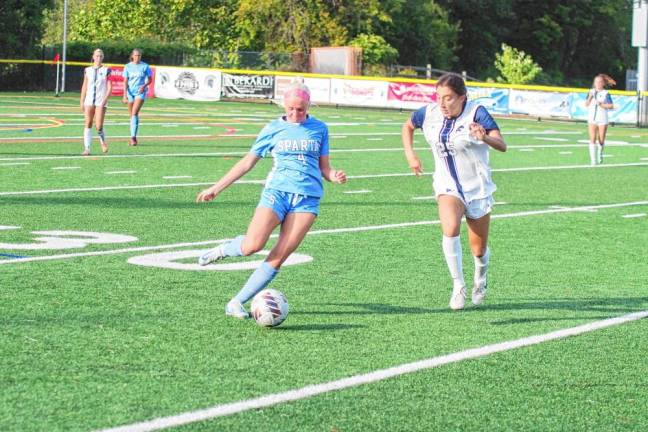 Sparta's Ingrid Brevig is about to kick the ball as Chatham's Lucy Arps approaches.