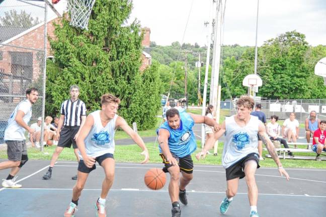 John Smalley, center, and two Team Reilly players reach for a loose ball.