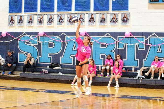 Sparta's Maggie Higgins leaps in the midst of a serve.