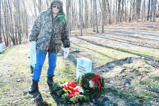 Frank Gawenus stands next to the grave of his cousin Robert Moran.