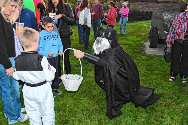 A costumed creature offers treats to children at the Hanging with Heroes event Friday, Oct. 11 in Sparta. (Photo by Maria Kovic)