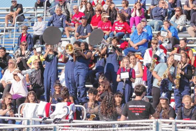 <b>Members of the Lenape Valley Regional High School Marching Band play their instruments in the stands among the Patriots football fans.</b>