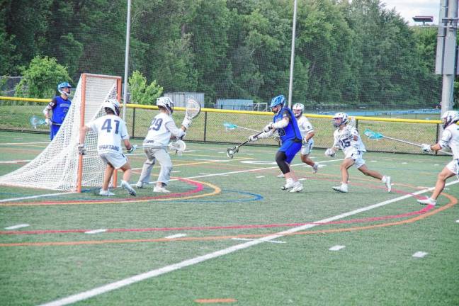 SL! Sparta is in a defensive mode as a West Morris ball carrier advances in the semifinal round of the NJSIAA North Jersey, Group 2 tournament May 31. West Morris won, 14-7. (Photos by George Leroy Hunter)