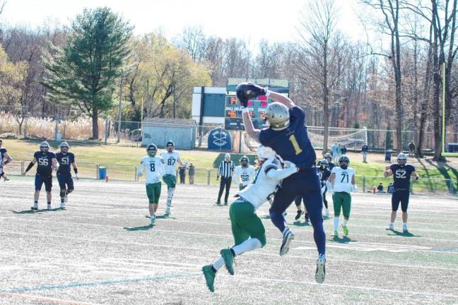 <b>After catching the ball, Pope John wideout Wes Johnston gets hit by a Camden Catholic defender in the second quarter. Johnston was able to hold onto the ball for a completion. (Photo by George Leroy Hunter)</b>