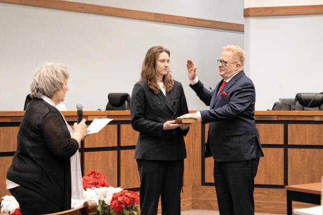 MS Mark Scott takes the oath of office as a Sparta Township Council member at the annual reorganization meeting Tuesday, Jan. 7. His daughter Erin Scott holds the Bible and Township Clerk Roxanne Landy administers the oath. (Photos by Dave Smith)